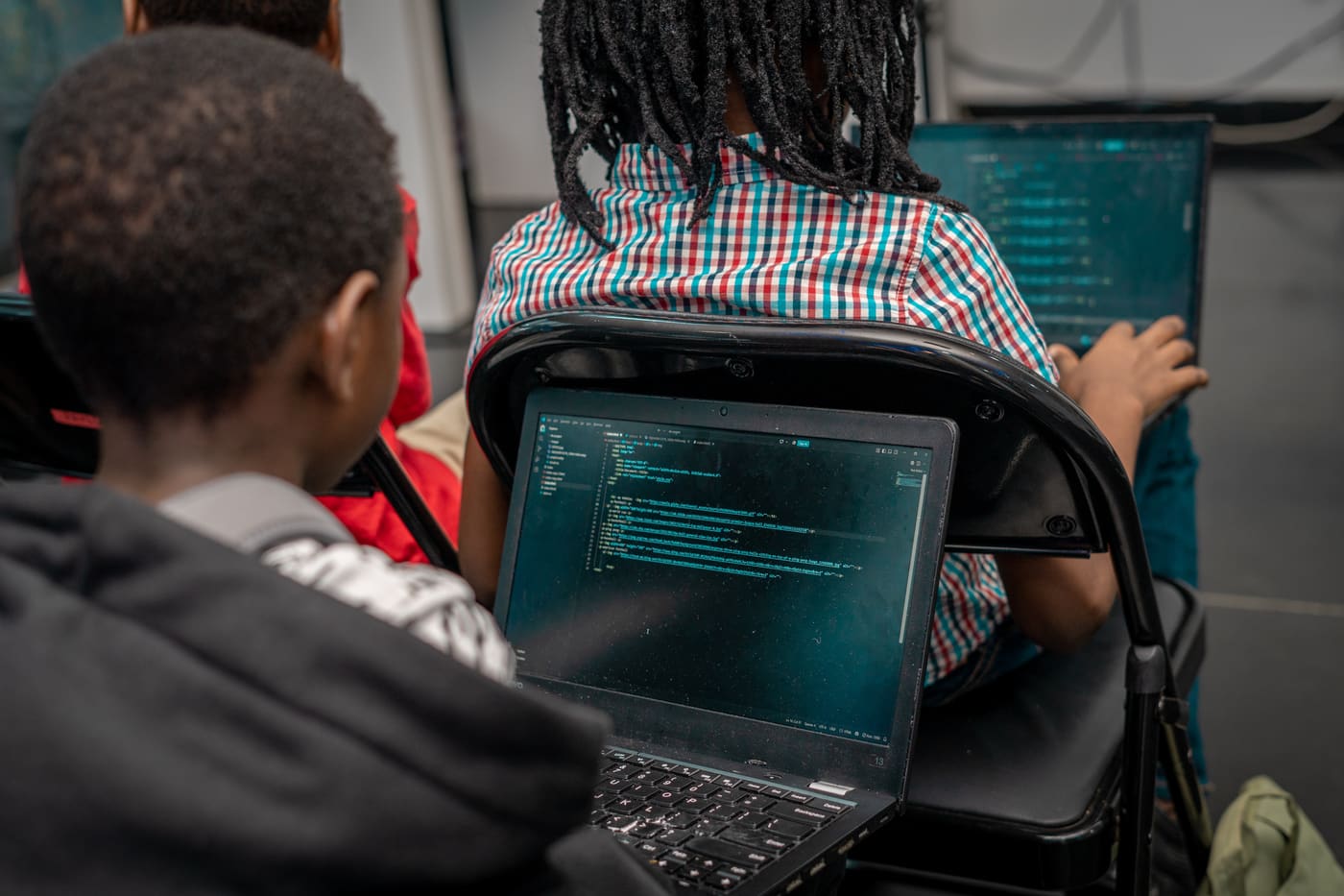 A student writing code on a laptop