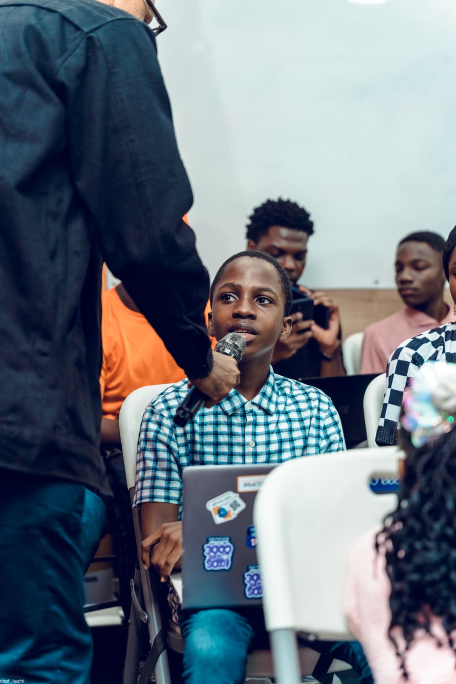 A student speaking into a microphone at demo day